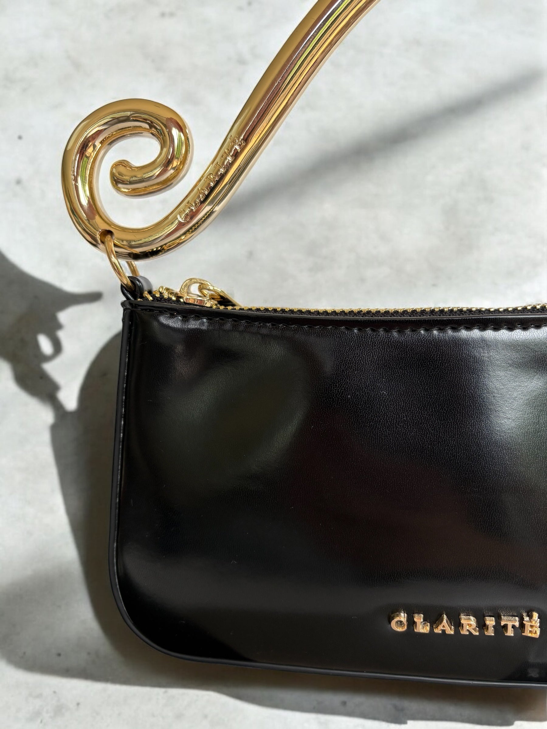 closeupclariteGoldandBlackEveningbagstatementbiggoldhandleswirldetailformalcocktail